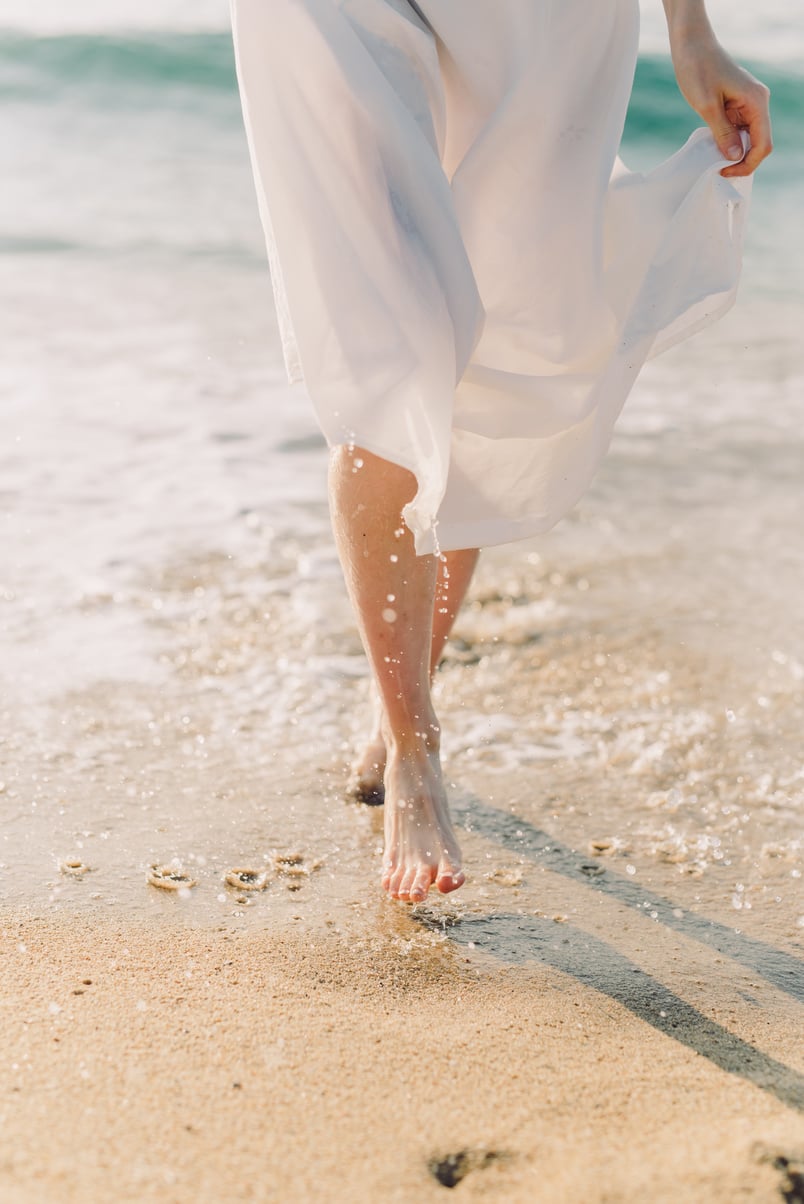 Woman in White Dress Walking on Beach